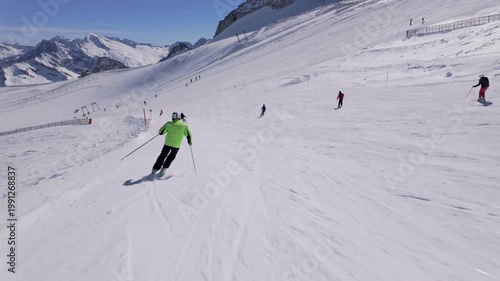 Skier carve turns on a pristine snowy piste during a clear winter day. Slow motion view	