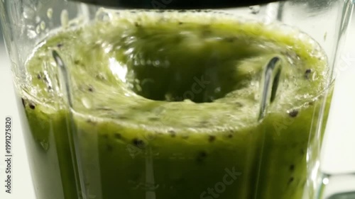 Fresh Green Kiwi Smoothie Blending in Glass Blender With Seeds and Pulp Close Up View
