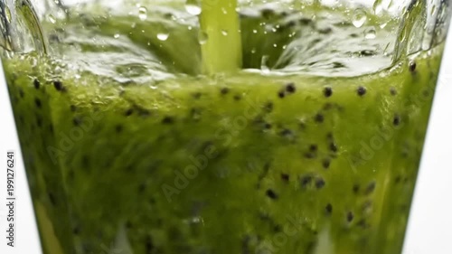 Fresh Green Kiwi Smoothie Blending in Glass Blender With Seeds and Pulp Close Up View