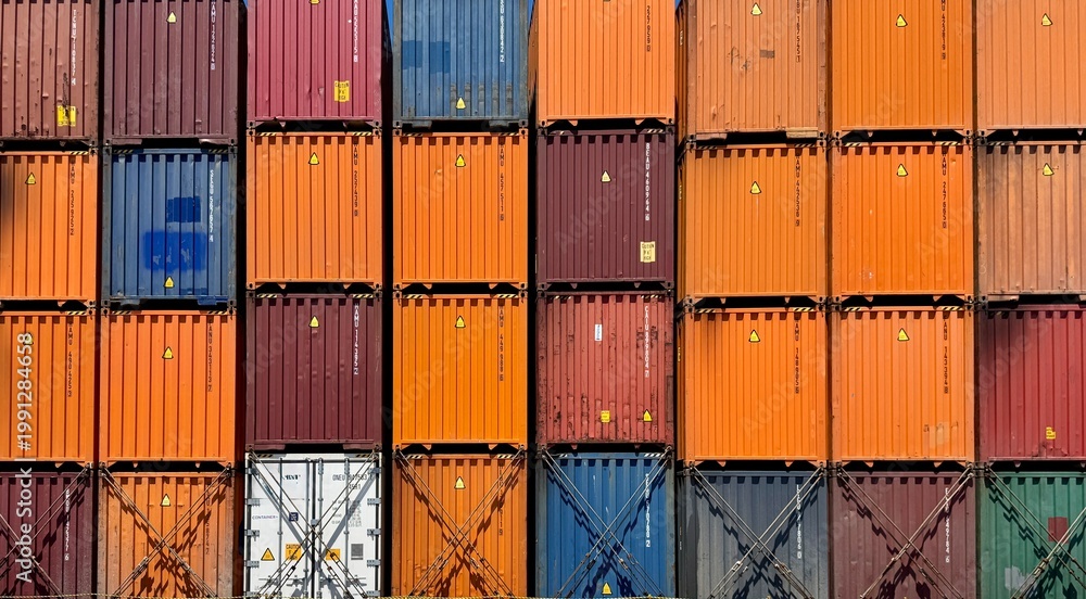 Fototapeta premium Close-up pattern of stacked cargo containers in various colors, representing logistics, global trade, industrial design, and structured geometric composition