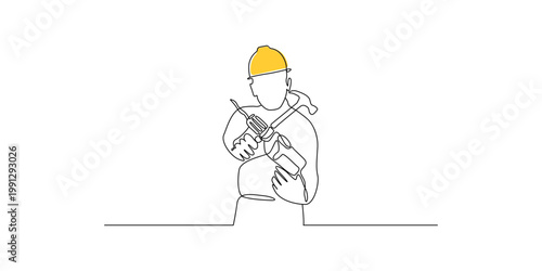 Construction worker in yellow hard hat holding tools with construction site manual labor skilled trade tool belt