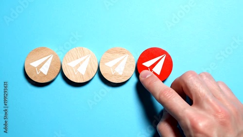 Hand pointing to a red circle with a paper airplane icon, symbolizing sending a message.