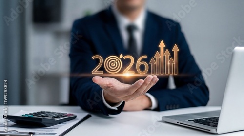 A businessman holding a glowing 2026 target with growth charts in his hand