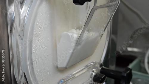 Ice cream maker machine. Ice cream falls into container.