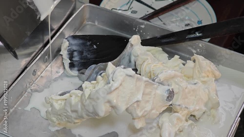 Ice cream maker machine. Ice cream falls into container.