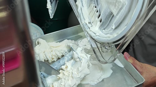 Ice cream maker machine. Ice cream falls into container.