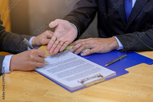 Businessman puts signature on contract at business meeting after negotiations with business partners. Selected focus