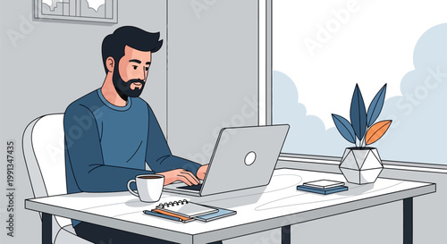 A bearded man working on his laptop at a desk.