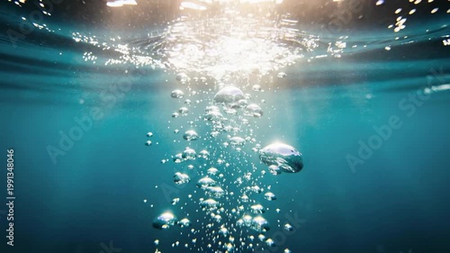 Underwater bubbles rising slowly toward the surface illuminated by gentle sunlight in serene ocean scene