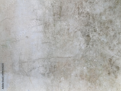 A textured concrete surface shows signs of aging and wear. This weathered concrete displays subtle cracks and discoloration.