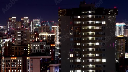 Timelapse of a modern apartment building at night with windows and lights turning on