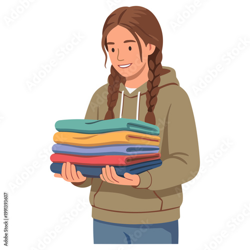 A smiling woman holding a stack of colorful folded clothes in her hands