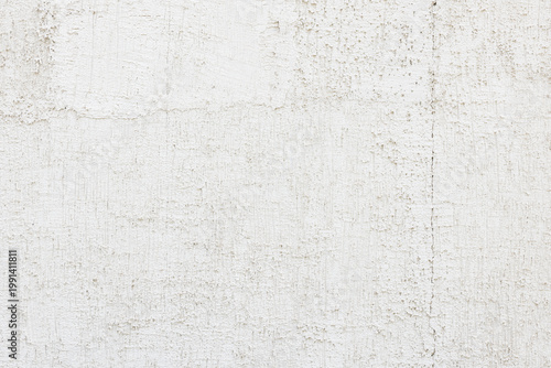 Textured white wall with cracks on building facade