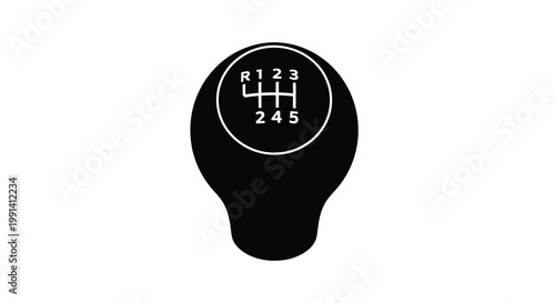 A black shift knob displaying a five speed manual transmission pattern