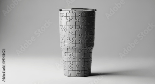A puzzle cup sits on a plain surface with a subtle shadow cast to the side in a studio.