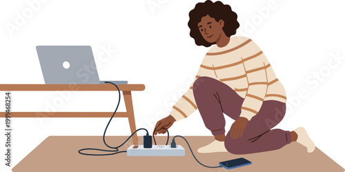 A woman is sitting on the floor plugging a cord into an extension cord next to her laptop.