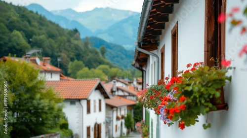 Picturesque rural village nestled in a scenic mountain valley featuring traditional white houses with terracotta roofs wooden accents and abundant blooming flower boxes