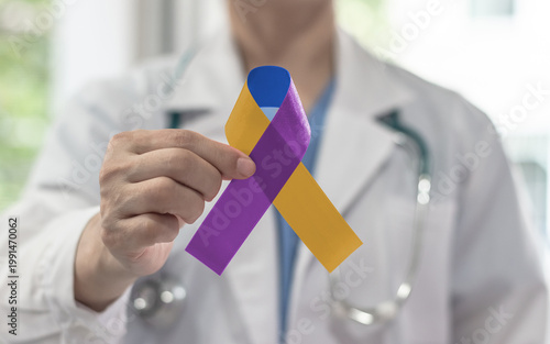 Bladder cancer awareness ribbon in marigold blue purple symbolic bow color on in doctor hand to support patient with tumor illness in May month