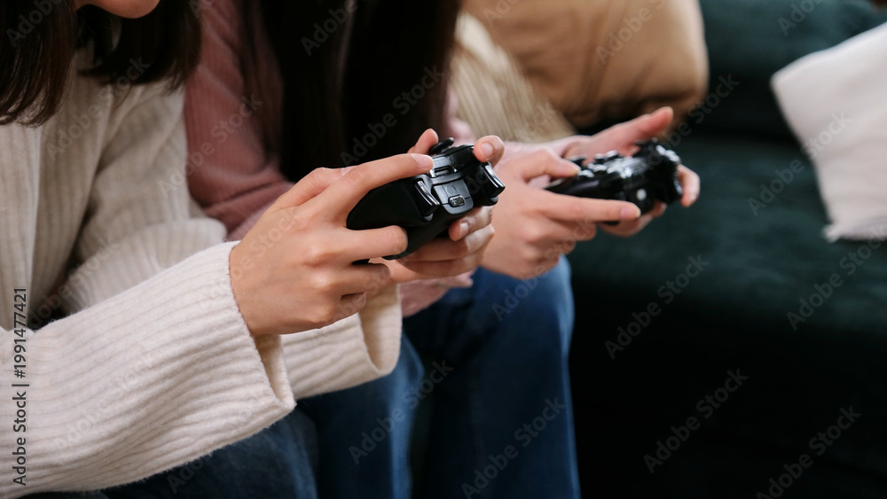 Fototapeta premium Two people are holding game controllers, actively engaged in playing a video game at home