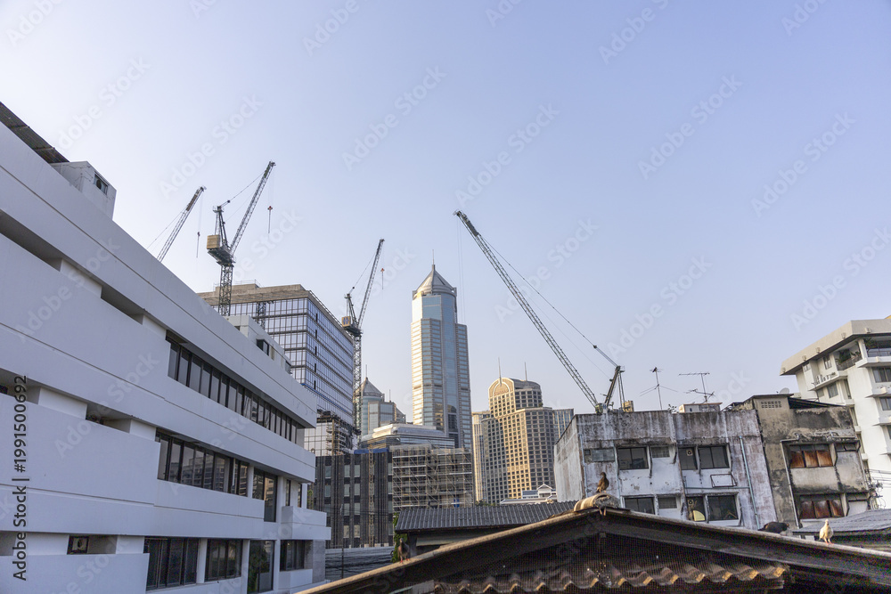 Fototapeta premium Energetic urban city undergoing rapid construction and development, with tall crane building modern skyscraper, blending fresh architecture into dynamic skyline for bustling view