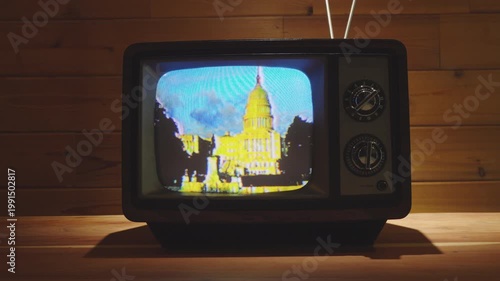 Vintage Television with footage of US Capitol Building in living room with wooden background. 