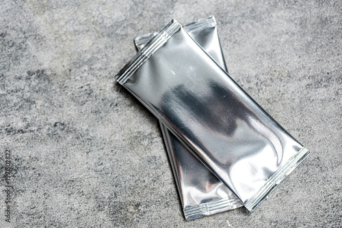 Blank trading card collectible game with shiny foil plastic booster pack mockup. Top view