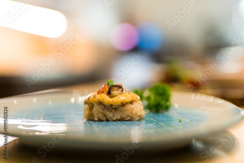 Foie Gras sushi with creamy sauce and toppings with salmon roe for a burst of saltiness and a sprig of green onion or microgreens for color and freshness