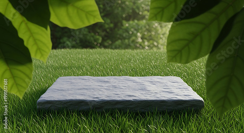 a gray stone podium on lush green grass surrounded by large leaves, ideal for product display, marketing, or presentation in a natural setting