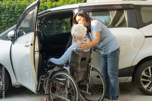 Caregiver help Asian elderly woman disability patient get into car.