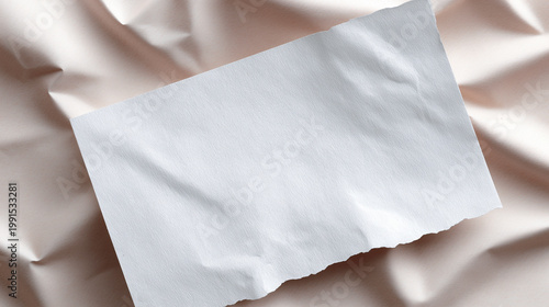 Blank textured paper sheet on soft fabric background used for mockup design and branding presentation