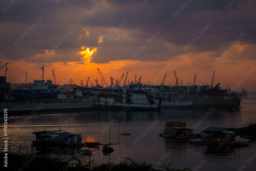 Naklejka premium Industrial Harbor at Sunset with Cranes and Ships
