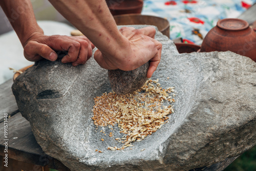 Tableau sur toile Human hand rotating an ancient stone grinding machine for smashing grains