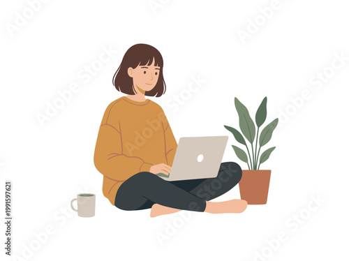 A young woman sitting cross-legged on the floor working on her laptop.