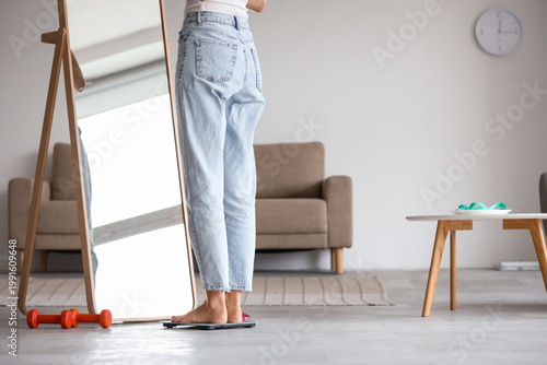 Young woman measuring her w...