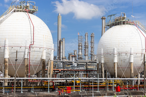 Industrial gas storage sphere tank at oil and gas refinery and petrochemical plant under blue sky, Oil and gas refinery plant and petrochemical industry infrastructure with gas storage tank pipeline.