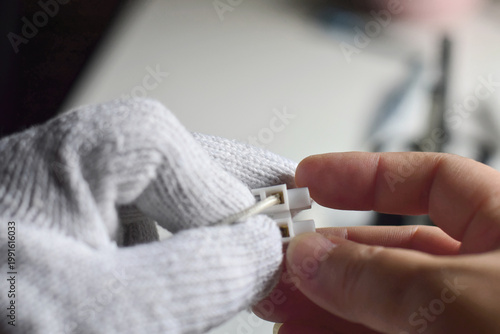 The electrician is using a voltage tester screwdriver to connect the wires.