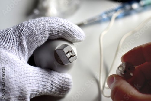 The electrician is connecting the wiring to the light bulb.