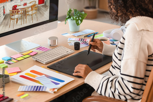 Female African-American interior designer working with graphic tablet in office