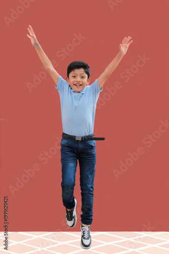9-year-old Latino boy with dark skin jumps for joy to celebrate his excitement