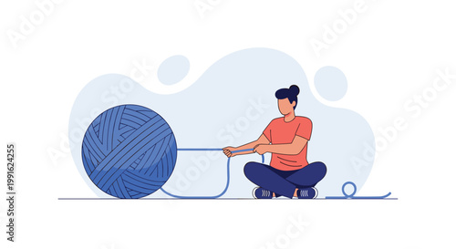 A woman sits cross-legged on the floor while meticulously unraveling a massive ball of vibrant blue yarn for a project in a minimalist indoor setting.