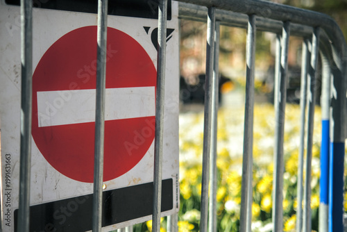 Картината върху платно Barrier with do not enter sign blocking access to a blooming field, symbolizing restriction, climate pressure and shrinking nature