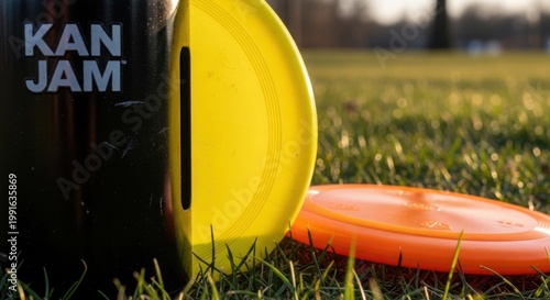 Fun Kan Jam game setup with yellow and orange frisbees on grassy field. Exciting outdoor activities include competitive frisbee throwing and teamwork.