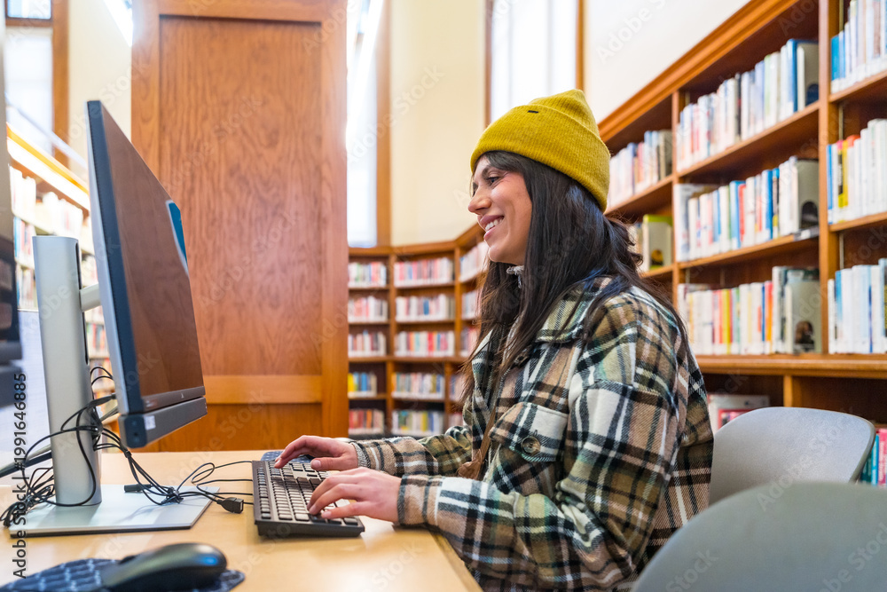 Obraz premium Young woman studying, learning and researching in san francisco library