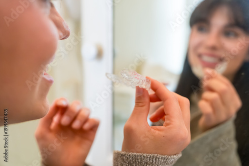 Foto Woman holding clear dental aligners for oral health