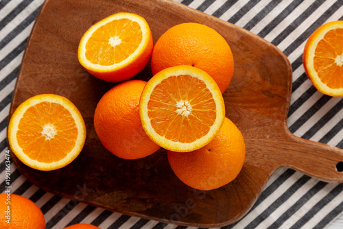Quadro su tela Raw Organic Oranges on a Wooden Board, top view