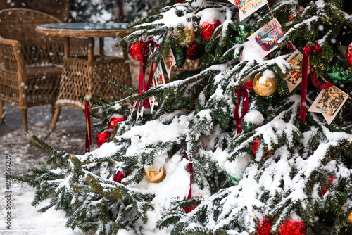 Beautiful Christmas background. Concept of decorations and decor for the new year 2027. Christmas tree with red and gold decorations in the snow.