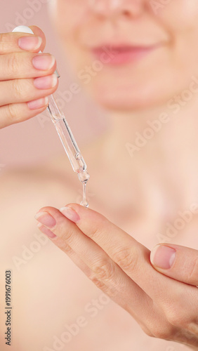 Konstfotografi Young woman holding a dropper with serum for face