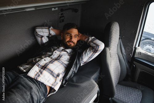 Canvas Print Truck driver resting inside sleeper cab during break