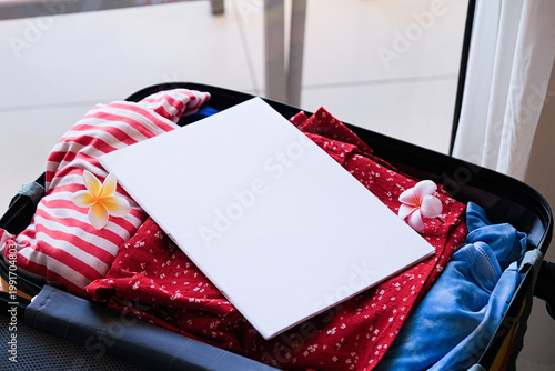 opened packed suitcase on bed in hotel room with white magazine mockup