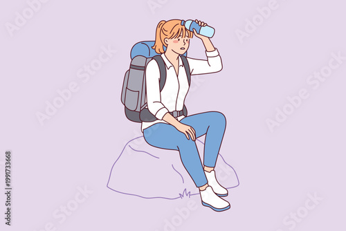 Young woman hiker resting on a stone during mountain trek. Tired girl cooling her forehead with water bottle during hot weather expedition.